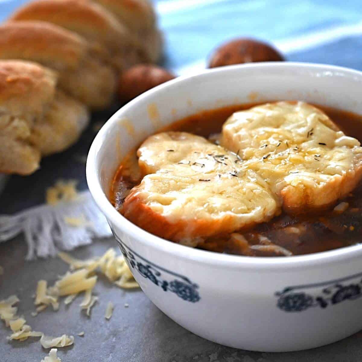 A bowl of vegetarian French onion soup topped with cheesy toast.